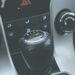 Detailed view of a manual gear shift knob and car console interior.